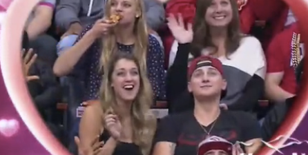 This American girl got caught rapid hoovering up pizza on a Kiss Cam
