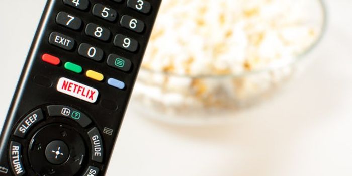 Zagreb, Croatia - March 5, 2016: Remote control smart TV with Netflix button with popcorn in the background.