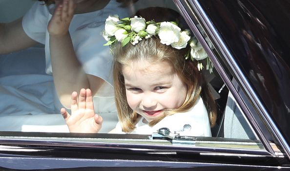 WINDSOR, ENGLAND - MAY 19: Princess Charlotte waves to the crowd as she rides in a car to the wedding of Prince Harry and Meghan Markle at St George's Chapel in Windsor Castle on May 19, 2018 in Windsor, England. (Photo by Andrew Milligan - WPA/Getty Images)